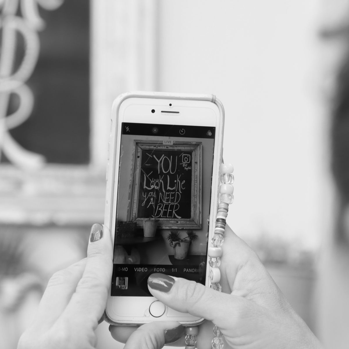 Personne photographiant un mur avec son smartphone pour documenter un désordre de construction